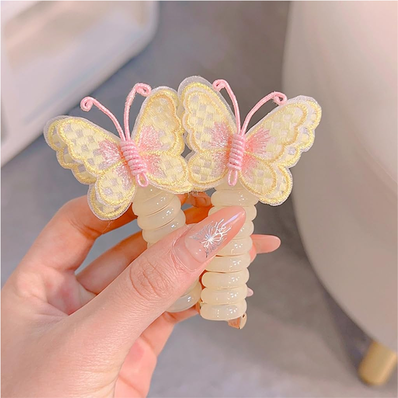 Two pink and yellow butterfly charm hair ties on a white background